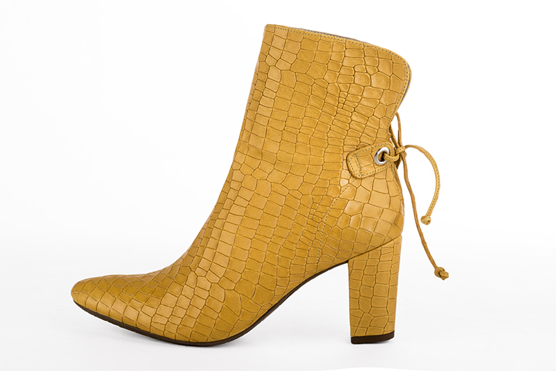 Mustard yellow women's ankle boots with laces at the back. Round toe. High block heels. Profile view - Florence KOOIJMAN